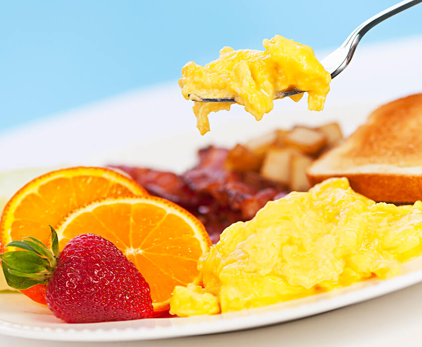 breakfast plate of eggs, fruit, and toast